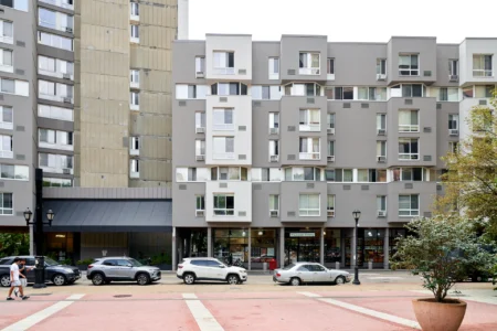 The Landings apartment buildings facing a paved plaza with storefronts and parked cars.