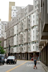 Residential street at The Landings with apartment buildings, a pedestrian and parked cars.