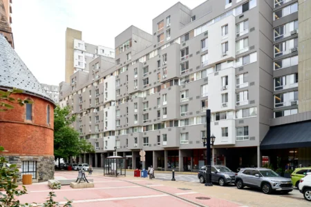 Long exterior view of The Landings apartment buildings along a residential street.